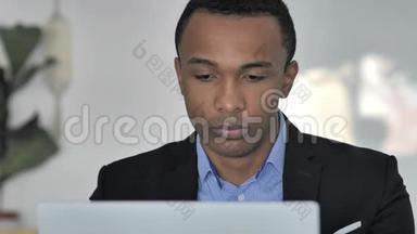 近距离接触在笔记本电脑上工作的休闲非裔美国商人